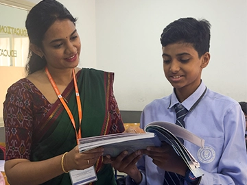 Teacher assisting student as part of Kuwait middle school programs.