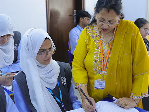 Teacher assisting student as part of Kuwait middle school programs.